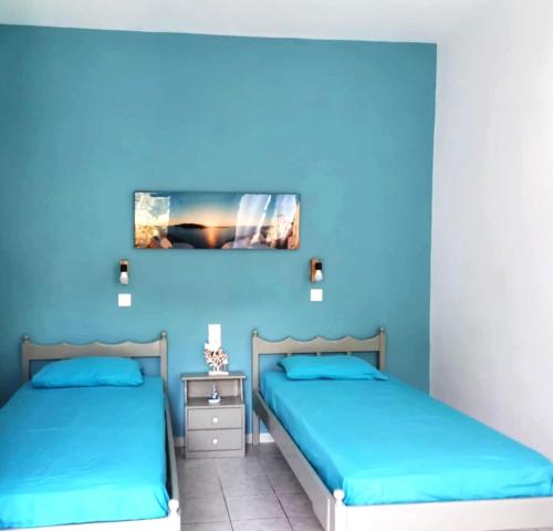 two beds in a room with blue walls at Valentino Apartment Kalymnos in Panormos Kalymnos