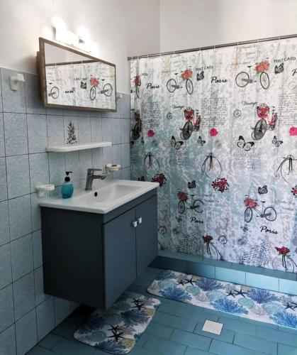a bathroom with a sink and a shower curtain at Valentino Apartment Kalymnos in Panormos Kalymnos