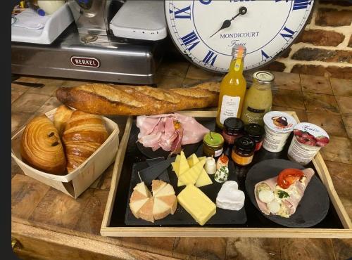 a table with a plate of food and a clock at Cozy vintage BNB house in Yerville