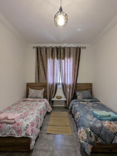 a bedroom with two beds and a window at Dar SAÏDA in Marrakech