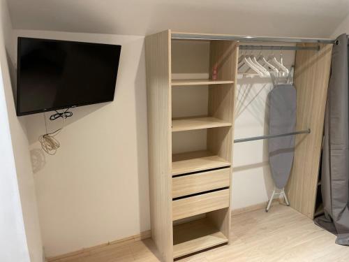a closet with a flat screen tv and a closet with shelves at Cozy vintage BNB house in Yerville