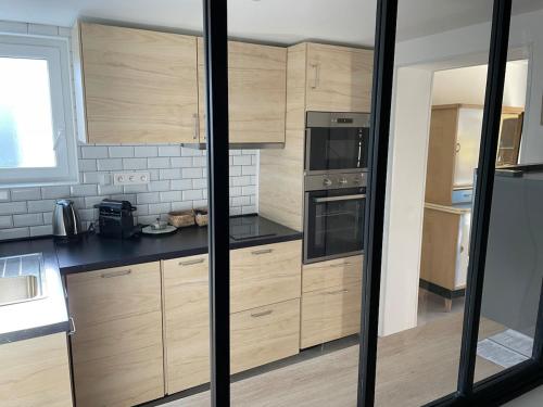 a large kitchen with wooden cabinets and appliances at Cozy vintage BNB house in Yerville