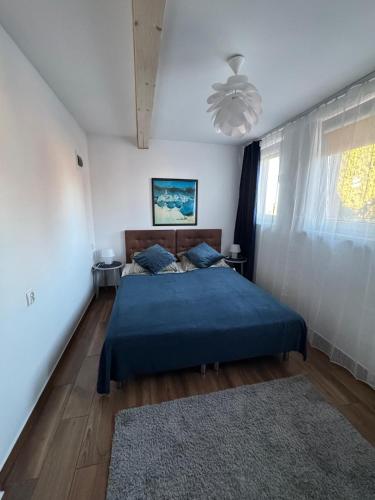 a bedroom with a blue bed and a window at Pensjonat E&M in Mikołajki