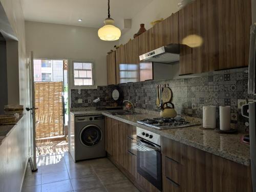 a kitchen with a stove and a washing machine at Dar SAÏDA in Marrakech