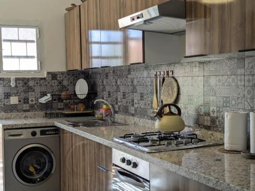 a kitchen with a stove and a washing machine at Dar SAÏDA in Marrakech