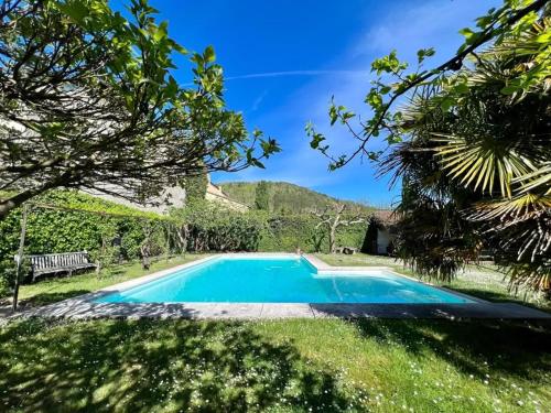 a blue swimming pool in a yard with trees at "La Verrerie haut" piscine, parking, proche du centre in Cahors