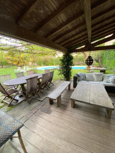 a patio with benches and a table and a couch at "La Verrerie haut" piscine, parking, proche du centre in Cahors