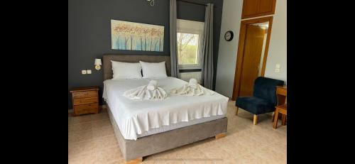 a bedroom with a bed and a blue chair at Akrotiri studios in Samothráki