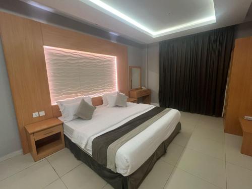 a bedroom with a large bed with a window at فندق أجنحة سمو - smo suites hotel in Riyadh