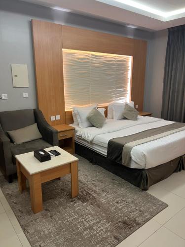 a hotel room with a bed and a chair at فندق أجنحة سمو - smo suites hotel in Riyadh