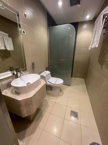 a bathroom with a toilet and a sink and a shower at فندق أجنحة سمو - smo suites hotel in Riyadh