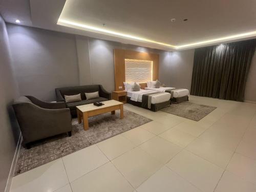 a living room with a couch and a bed and a table at فندق أجنحة سمو - smo suites hotel in Riyadh
