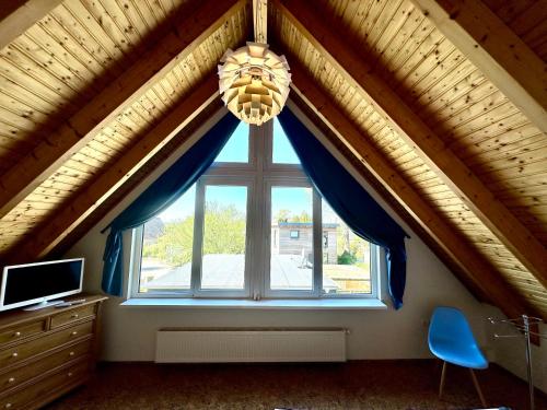 a room with a large window with blue curtains at Ferienhaus an der Schlei in Kappeln