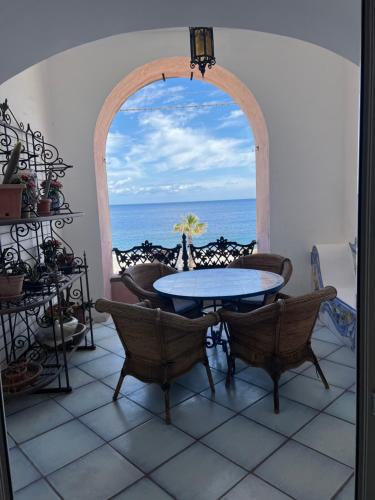 a table and chairs in a room with a view of the ocean at Casa Bacot in Canneto