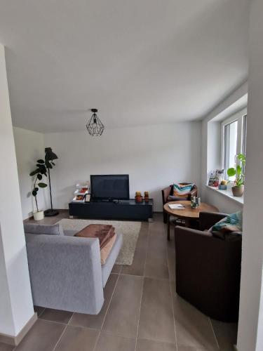 a living room with a couch and a table at FeWo mit großer Terrasse im Herzen der fränkischen Schweiz in Unterleinleiter