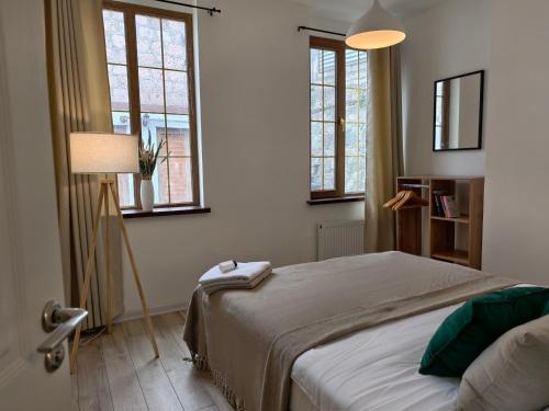 a bedroom with a bed and two windows at Ponti House Dilijan - beautiful 2 bedroom house and separate 1 bed unit, sleeps 6 in Dilijan