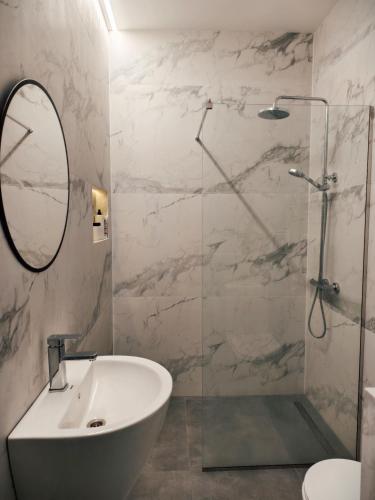 a bathroom with a shower and a sink and a mirror at Ponti House Dilijan - beautiful 2 bedroom house and separate 1 bed unit, sleeps 6 in Dilijan