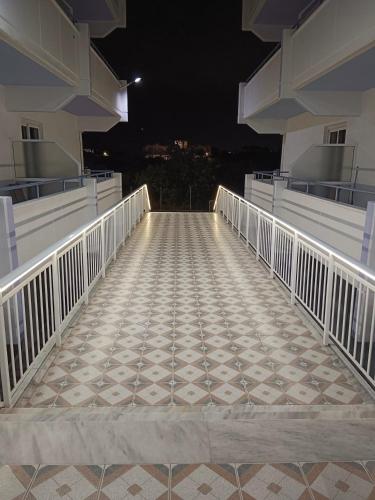 a walkway leading to a balcony at night at Pyrgos Hotel Apartments in Kremasti