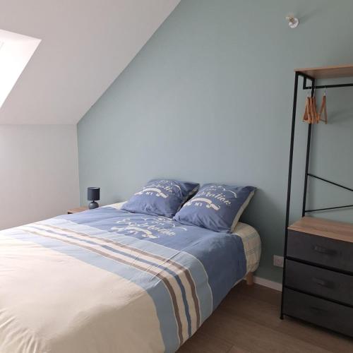 - une chambre avec un lit doté d'oreillers bleus et d'une commode dans l'établissement Ma Petite Maison, à Belz