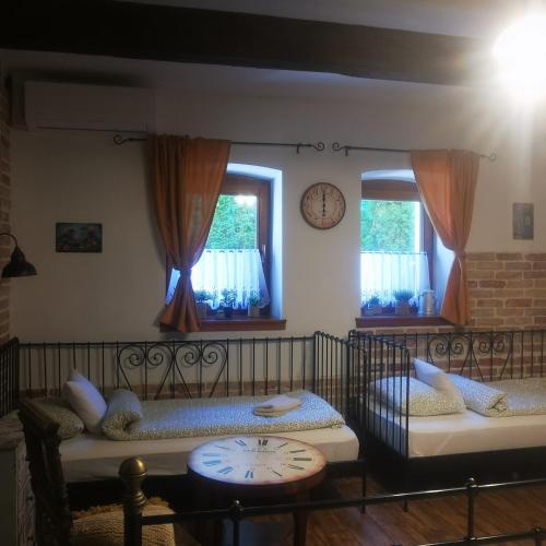 a room with two beds and a clock on the wall at Kúria Apartman Budapest with free parking in Budapest
