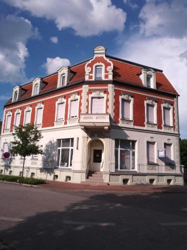 a large white and red building with a red roof at Ferienwohnung Poschmann in Bad Wilsnack