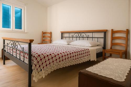 a bedroom with a bed and two chairs at House Natale in Donje Selo na Šolti