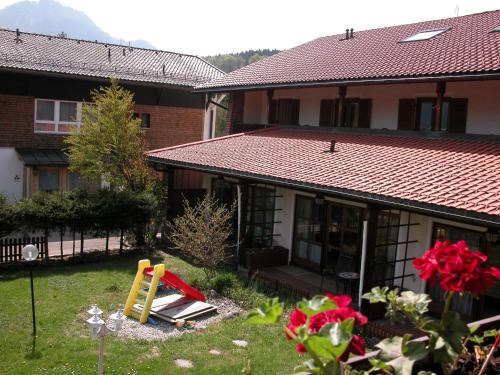 a house with a playground in the yard at Hotel-Restaurant Zum Hirschhaus Inklusiv Chiemgaukarte in Ruhpolding