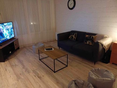 un salon avec un canapé et une table basse dans l'établissement la p'tite maison d'olima, à Épinal