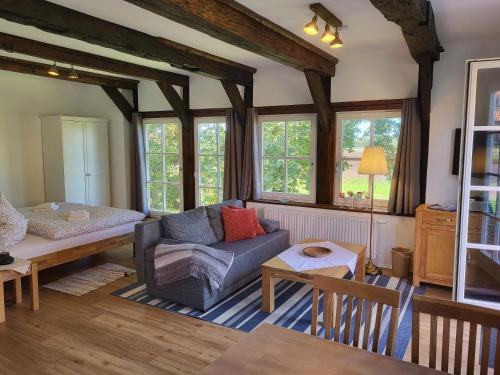 a living room with a couch and a bed at Altes Backhaus Bauernhof Vogel in Rohrsen