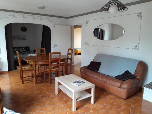 a living room with a couch and a table at Gîte meublé 10 personnes in Donges