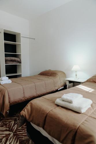 a hotel room with two beds and a table at Los Geranios Apart in Villa Cubas