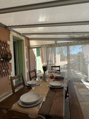 une table en bois avec des assiettes et des verres à vin dessus dans l'établissement Villa Tilia, à Nîmes