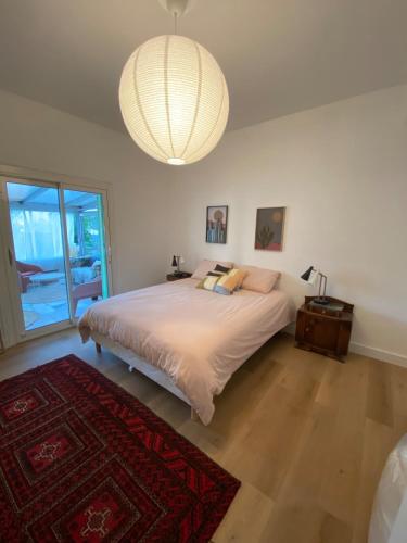 une chambre avec un lit et un lustre dans l'établissement Villa Tilia, à Nîmes