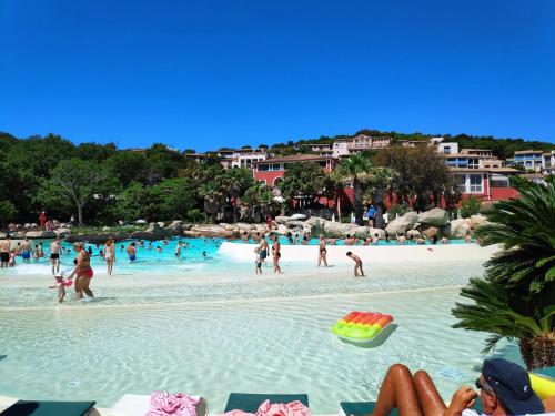 un groupe de personnes dans l'eau sur une plage dans l'établissement Superbe vue mer 2pièces, mezzanine, clim 5 personnes, à Grimaud