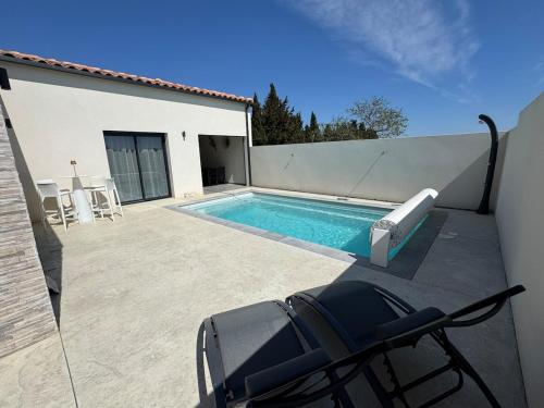 - une piscine sur le côté d'une maison dans l'établissement Villa moderne avec Piscine et cuisine extérieure, à Saint-Nazaire-dʼAude