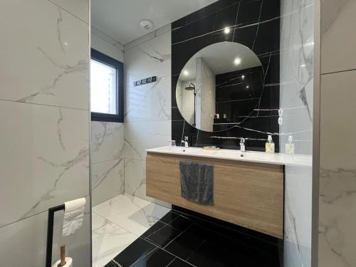 une salle de bain avec un lavabo et un miroir dans l'établissement Villa moderne avec Piscine et cuisine extérieure, à Saint-Nazaire-dʼAude
