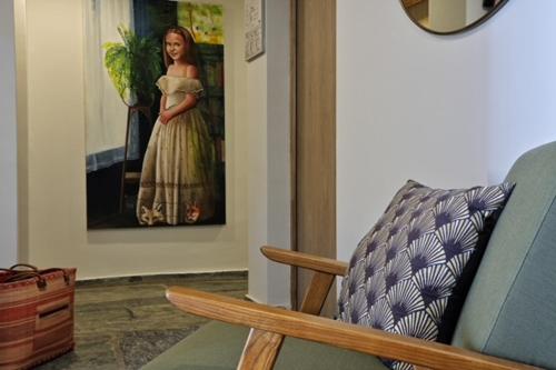 a room with a chair and a picture of a woman at Hotel Restaurant & Spa E Caselle in Venaco