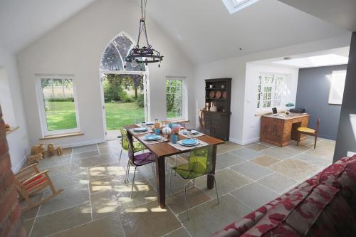 a dining room and living room with a table and chairs at Plantagenet, A Historic Country Cottage with Pool and Hot Tub in Boughton Aulph