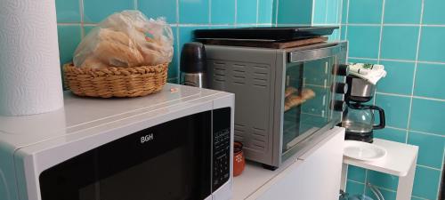 a microwave oven with a basket on top of it at Monis House in Buenos Aires