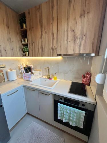 a kitchen with a sink and a stove top oven at Mk Lux Apartman in Soko Banja