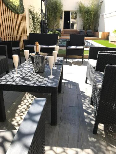 d'une terrasse avec une table et des verres. dans l'établissement Havre de paix avec Spa à deux pas de la plage, à Royan