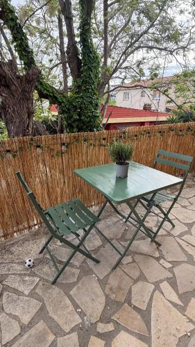 une table verte et une chaise avec une plante en pot dans l'établissement Seaside Studio with Terrace and Free Parking - Beach 2 Min Walk, à Villeneuve-Loubet