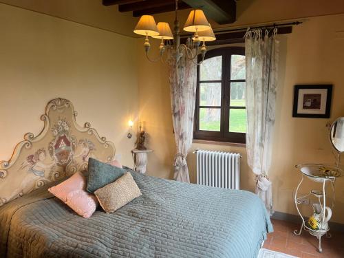 a bedroom with a bed with pillows and a window at Villa Bellora in Cortona