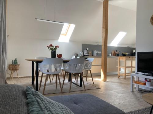 ein Wohnzimmer mit Tisch und Stühlen und eine Küche in der Unterkunft Egy présház tágas tetőtere mesés kilátással in Hegymagas