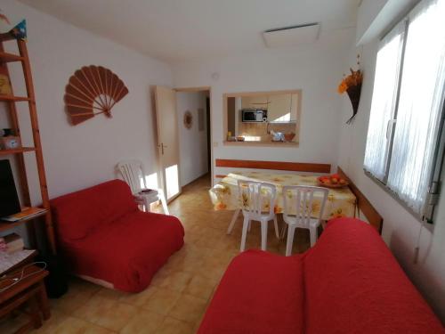 un salon avec une table et un canapé rouge dans l'établissement Estivales 2, à Saint-Raphaël