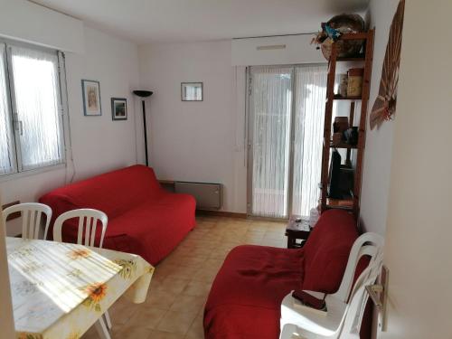 un salon avec un canapé rouge et une table dans l'établissement Estivales 2, à Saint-Raphaël