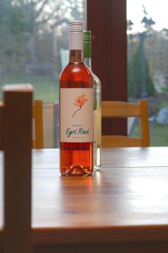 a bottle of wine sitting on a wooden table at Valley Vendégház in Eger