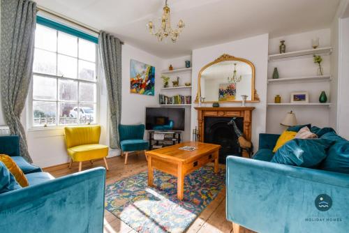 a living room with a blue couch and a fireplace at The Georgian House in Weymouth