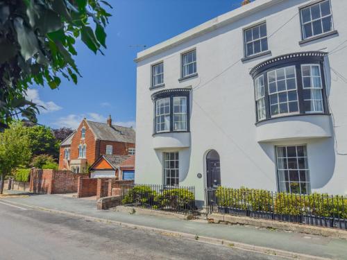 a white house with black windows on a street at The Georgian House in Weymouth