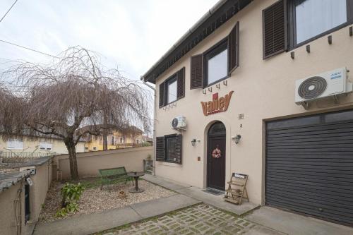 a building with a door and a sign on it at Valley Vendégház in Eger